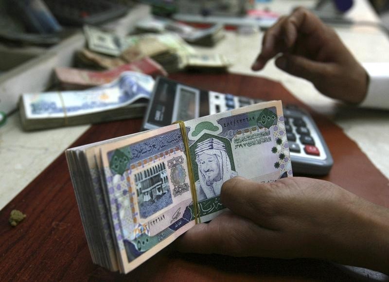 © Reuters. A Saudi money exchanger counts Saudi riyals in Riyadh