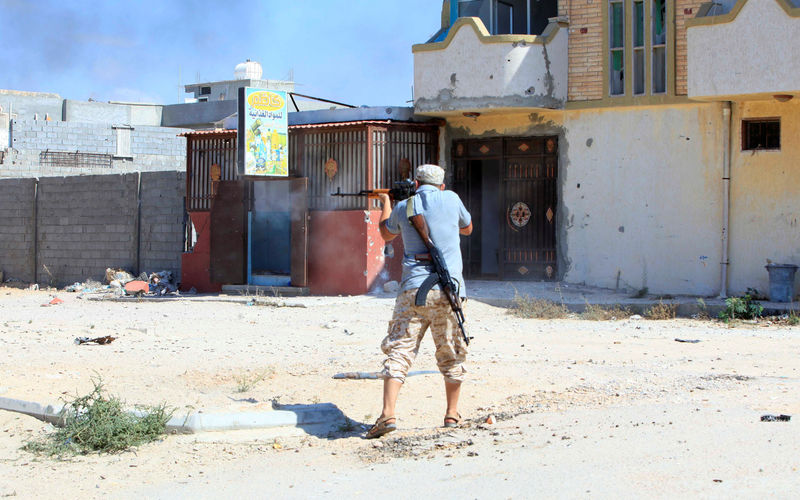 © Reuters. Member of Libyan forces allied with the UN-backed government fires a weapon towards Islamic State militants in neighbourhood Number One in central Sirte