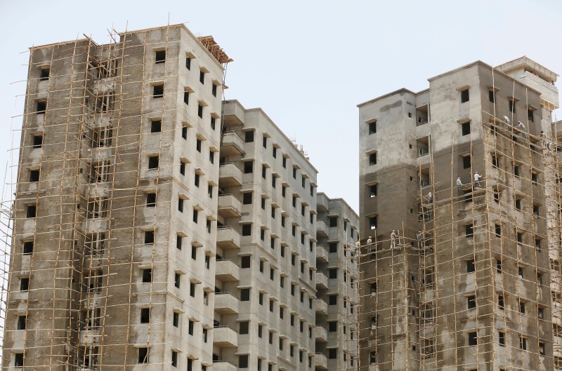 © Reuters. Labourers work at the site of an under construction residential complex on the outskirts of Ahmedabad