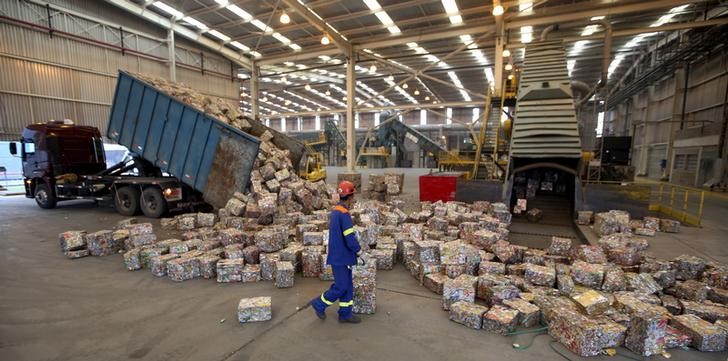 © Reuters. Em foto de arquivo, trabalhador caminha entre blocos de latas de alumínio prensadas em fábrica em Pindamonhangaba, Brasil