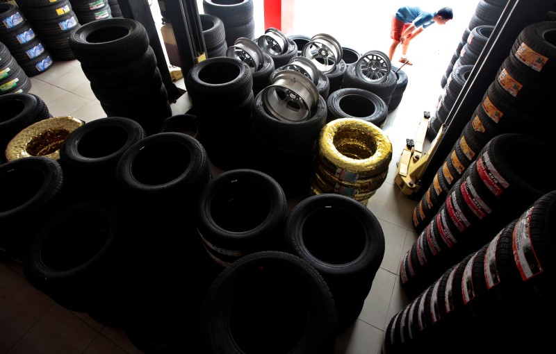 © Reuters. A man stands outside a tire store in Shanghai