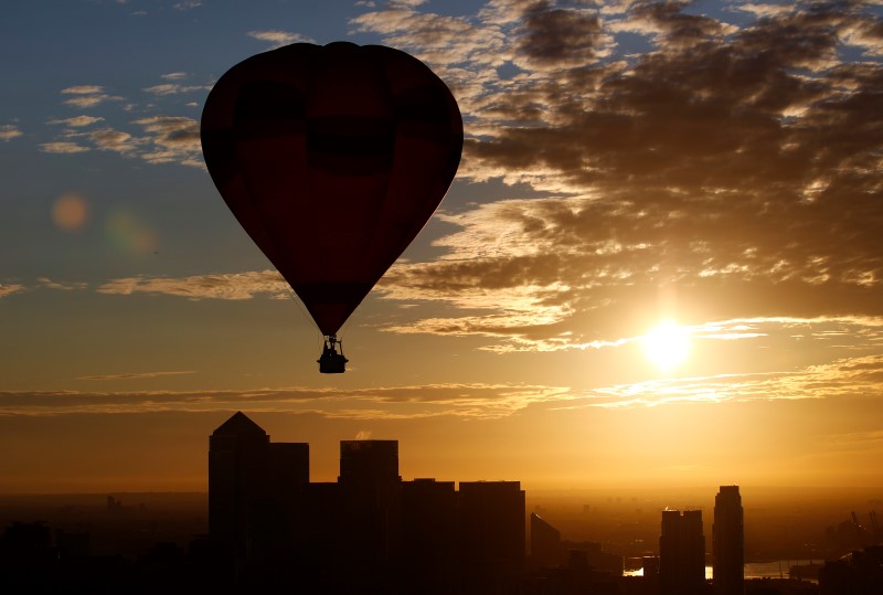 © Reuters. A hot air balloon rises into the early morning sky in front of the Canary Wharf financial district of London