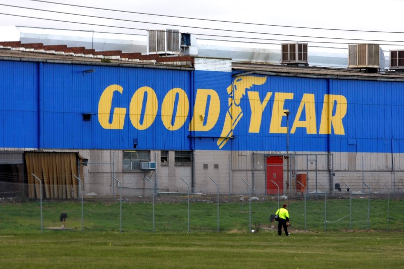 © Reuters. Man walks past the Goodyear logo at the South Pacific Tyres facility in Somerton