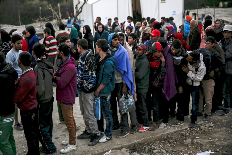 © Reuters. Refugees and migrants line up for a food distribution at the Moria refugee camp on the Greek island of Lesbos