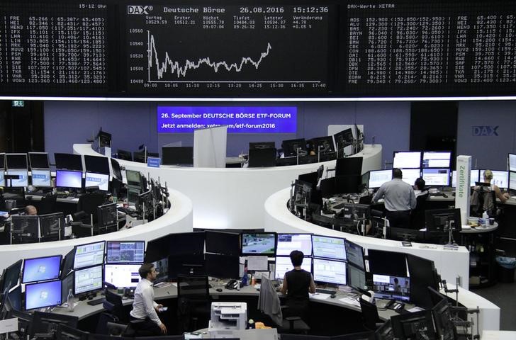 © Reuters. Traders work at their desks in front of the German share price index DAX board in Frankfurt