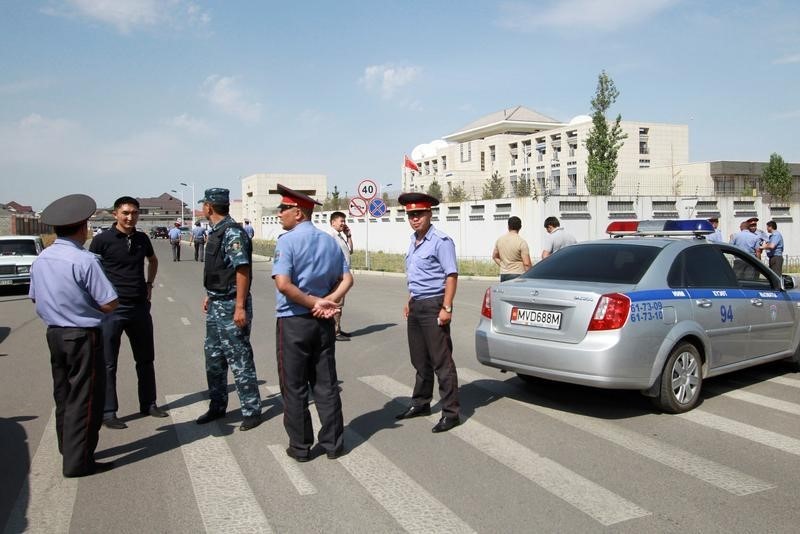 © Reuters. Investigadores ao lado de portões da embaixada chinesa em Bishkek, capital do Quirguistão