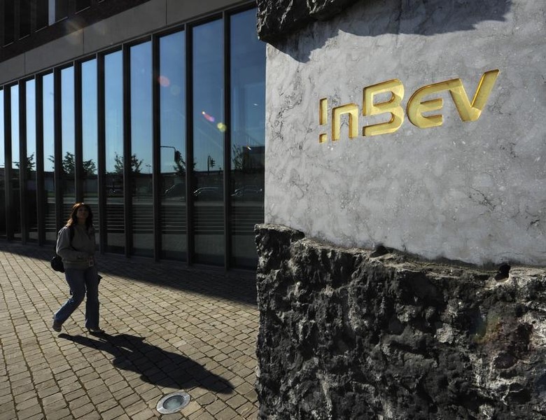 © Reuters. A woman walks outside the Anheuser-Busch InBev brewery headquarters in Leuven