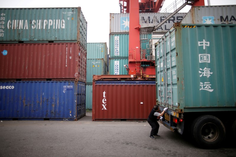 © Reuters. A truck driver checks a shipping container at a container terminal at Incheon port in Incheon