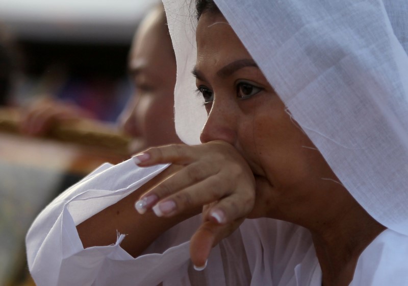 © Reuters. Wife of Kem Ley, an anti-government figure and the head of a grassroots advocacy group, "Khmer for Khmer", shot dead on July 10, reacts as she attends a funeral procession to carry his body to his hometown in Phnom Penh