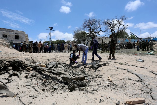 © Reuters. Somali security forces assess the scene of a car bomb outside the president's palace in the Somali capital of Mogadishu