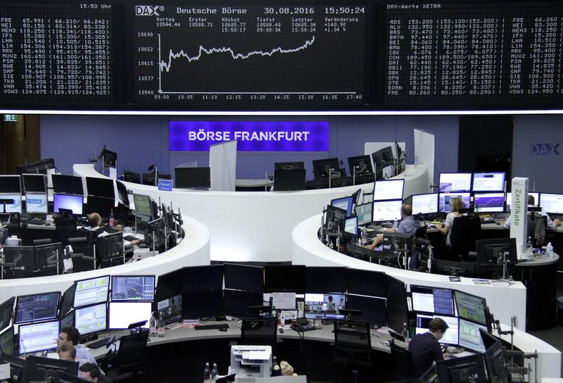 © Reuters. Traders work at their desks in front of the German share price index DAX board in Frankfurt