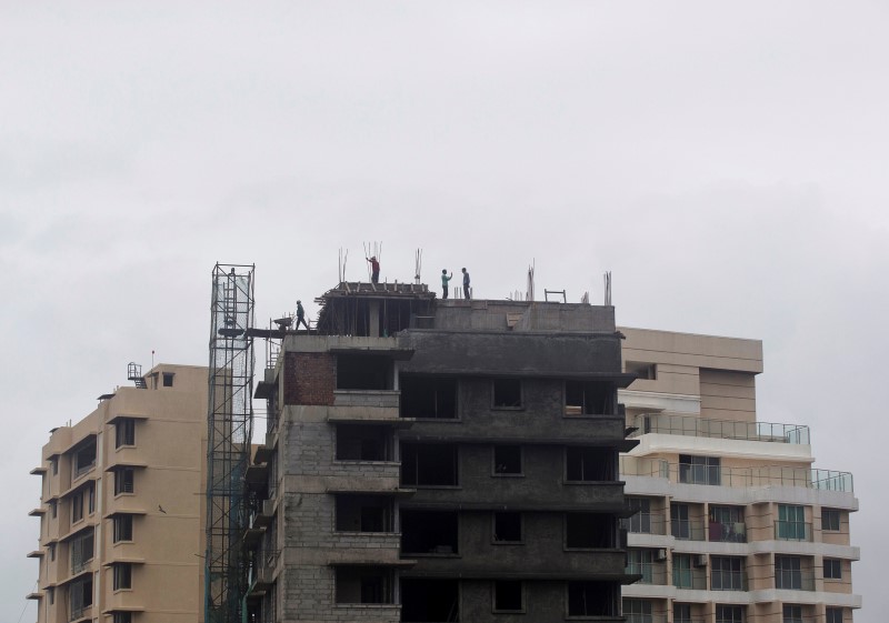 © Reuters. Labourers work at the site of an under construction residential building in Mumbai