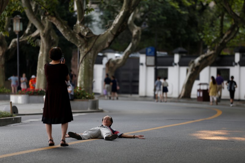 © Reuters. A man poses for photos on an empty road near the West Lake, as police closed off many roads before G20 Summit in Hangzhou