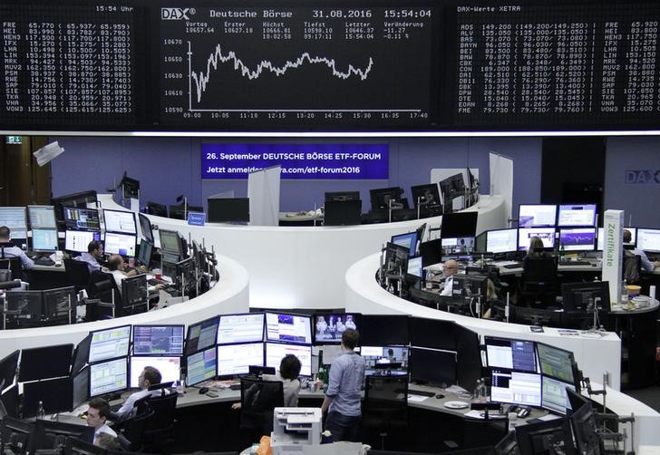 © Reuters. Traders work at their desks in front of the German share price index DAX board in Frankfurt