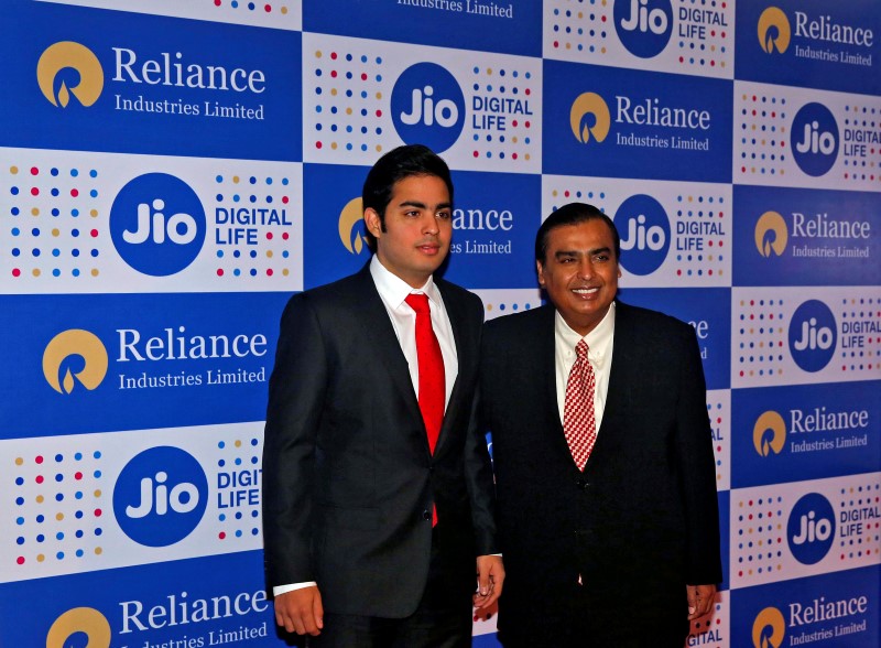 © Reuters. Mukesh Ambani, chairman of Reliance Industries Ltd, poses with his son Akash in Mumbai