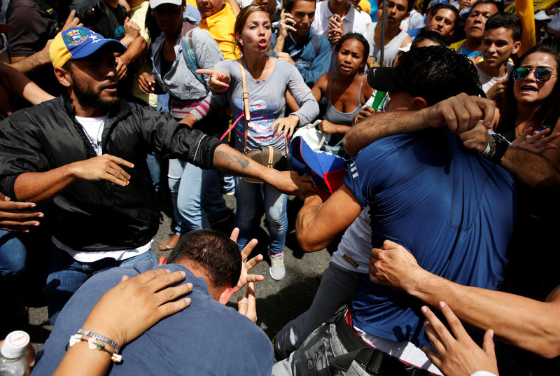 © Reuters. A fight breaks out after people thought a government supporter was amongst them during in a rally to demand a referendum to remove Venezuela's President Nicolas Maduro in Caracas