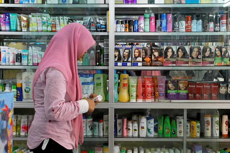 © Reuters. A saleswoman at a shop selling beauty products walks past a display cabinet while waiting for customers in a traditional market in Jakarta