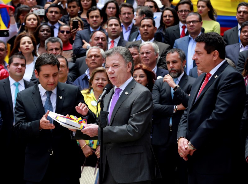 © Reuters. Presidente da Colômbia, Juan Manuel Santos (D) entrega acordo de paz firmado com as Farc ao presidente do Congresso da Colômbia, Mauricio Lizcano (E), em Bogotá