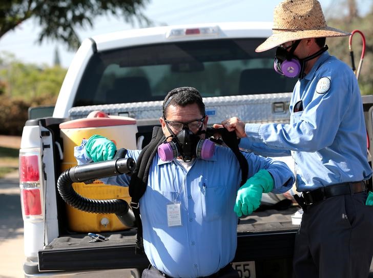 © Reuters. Homem recebe ajuda em San Diego, nos EUA, para colocar equipamento de dedetização durante combate ao mosquito transmissor do vírus Zika