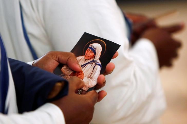 © Reuters. Freira das Missionárias da Caridade segura santinho da Madre Teresa durante missa em Washington