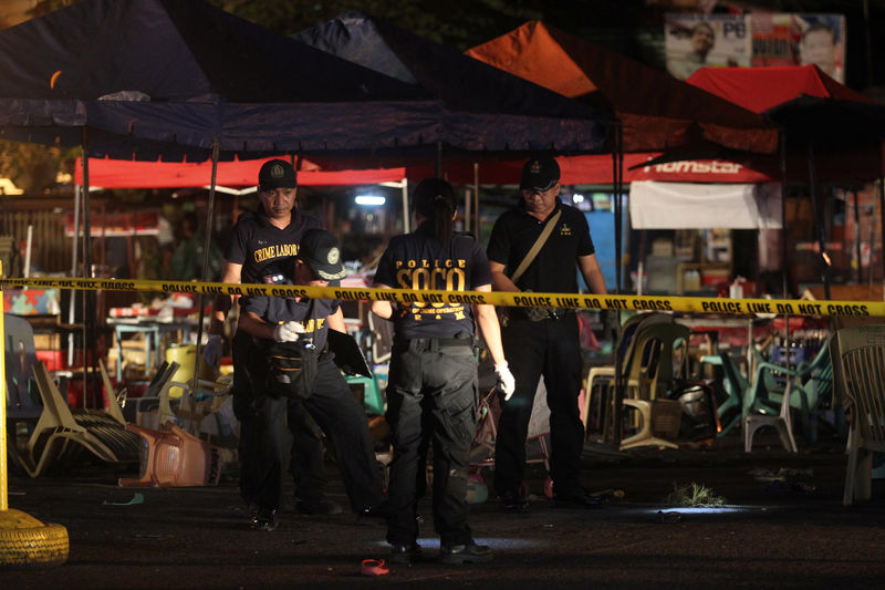 © Reuters. Police investigators inspect the area of a market where an explosion happened in Davao City