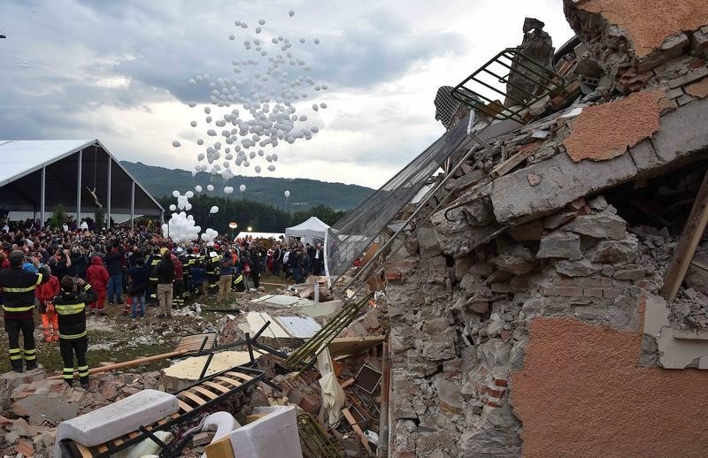 © Reuters. White balloons are released during funeral service for victims of the earthquake that levelled the town in Amatrice