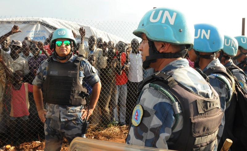 © Reuters. U.N. peacekeepers stand guard at a demonstration by people displaced in the recent fighting, during a visit by the United Nations Security Council, delegation to the UN House in Jebel, near South Sudan's capital Juba