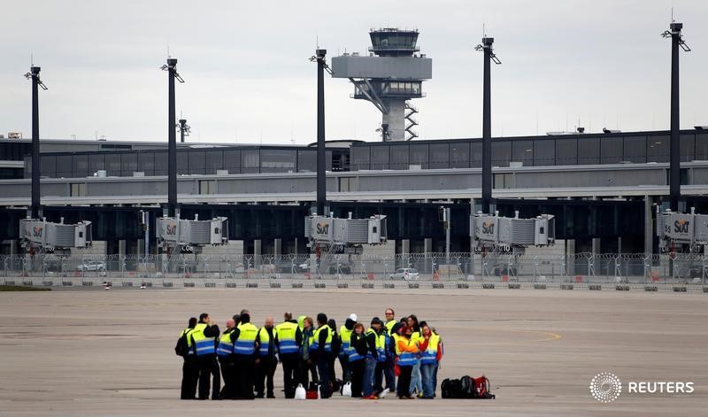 © Reuters. Participants of an emergency drill are seen in front of the tower and the main building of Berlin Brandenburg international airport Willy Brandt (BER) in Schoenefeld outside Berlin