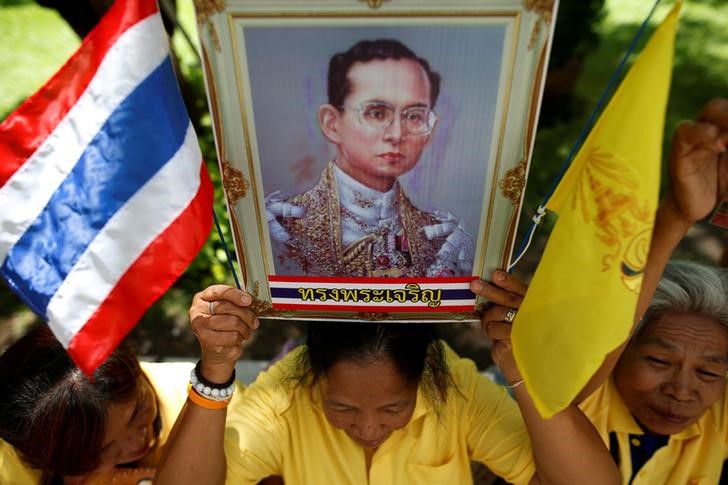 © Reuters. A well-wisher holds a picture of Thailand's King Bhumibol Adulyadej at the Siriraj hospital where he is residing, in Bangkok