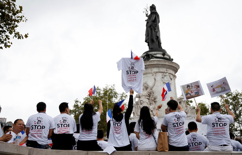 © Reuters. Demonstrators hold signs that read "Stop violence, aggression and insecurity" at a rally of the Chinese community to raise awareness about recent racists attacks in Paris, France