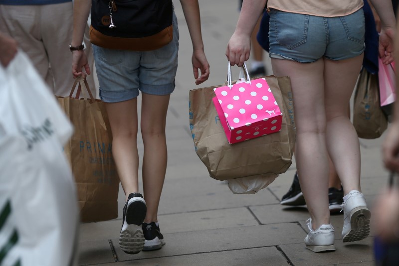 © Reuters. Shoppers carry bags in London