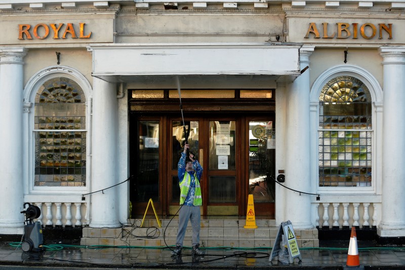 © Reuters. A worker hoses down the entrance to a hotel in Brighton southern England