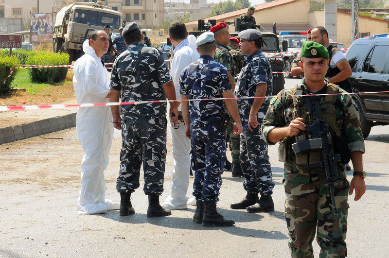 © Reuters. Lebanese army soldiers, policemen and forensic experts examine the site of a bomb blast near the city of Zahle