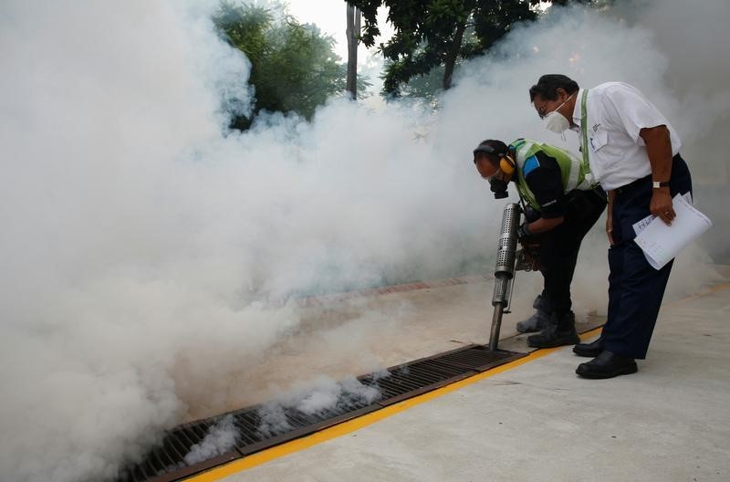 © Reuters. A worker fogs the drains in the common areas of a public housing estate at an area where locally transmitted Zika cases were discovered in Singapore