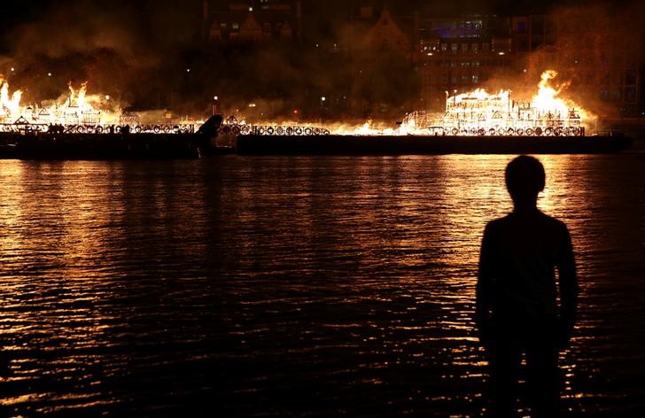 © Reuters. Menino observa réplica de 120 metros de Londres do século 17 pegando fogo à beira do Rio Tâmisa  para celebrar o Grande Incêncio de Londres de 1666