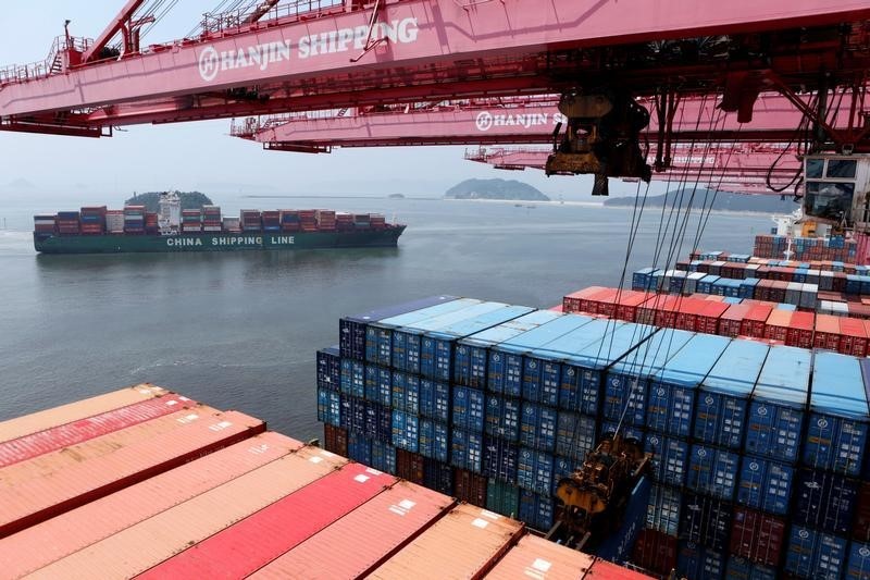 © Reuters. Crane carries a container from a Hanjin Shipping ship at the Hanjin container terminal as a China Shipping Line ship arrives at the Busan New Port