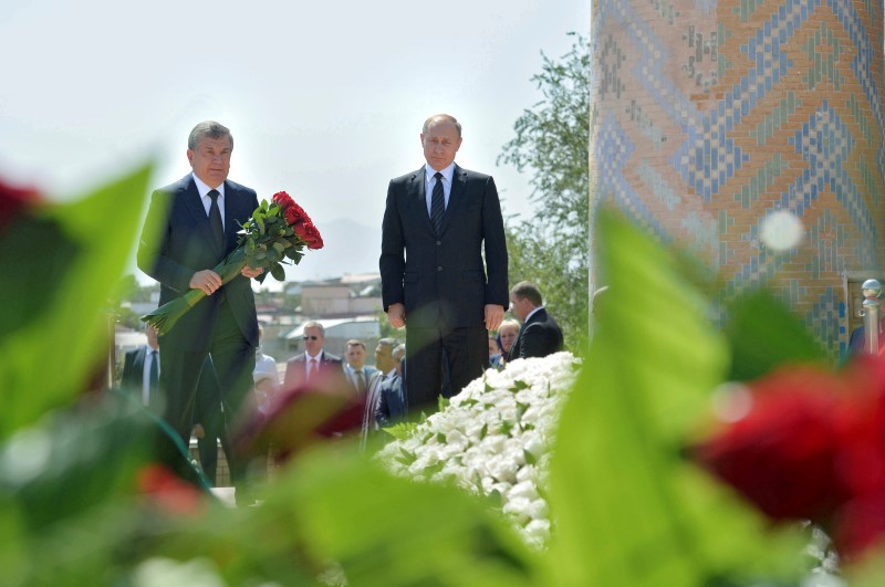 © Reuters. Russian President Vladimir Putin and Uzbek Prime Minister Shavkat Mirziyoyev lay flowers at grave of late Uzbek President Karimov in Samarkand
