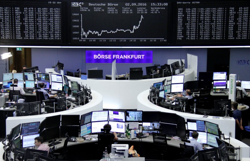 © Reuters. Traders work at their desks in front of the German share price index DAX board in Frankfurt