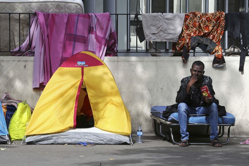 © Reuters. A migrant is seen at a makeshift camp on a street in Paris