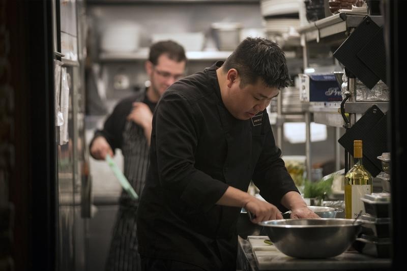 © Reuters. A cook is seen working in the kitchen at restaurant Marc Forgione in New York