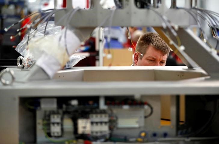 © Reuters. A worker examines an electrical component on the factory floor of PP Control and Automation near Cannock