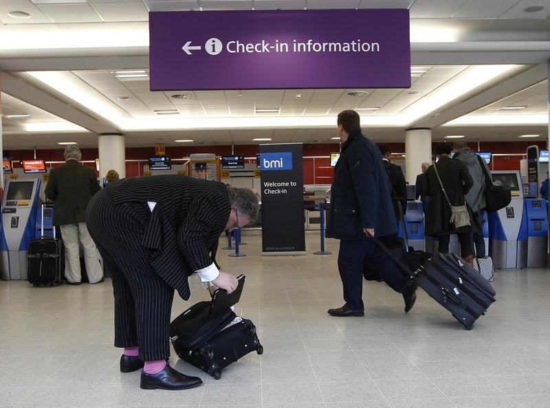 © Reuters. Passengers walk with their luggage at Edinburgh airport in Scotland