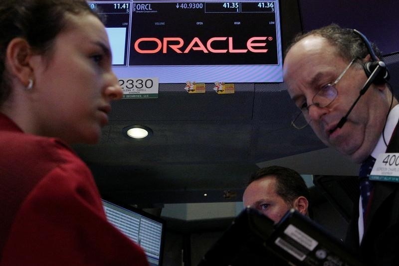 © Reuters. Traders gather at the post where Oracle is traded on the floor of the NYSE