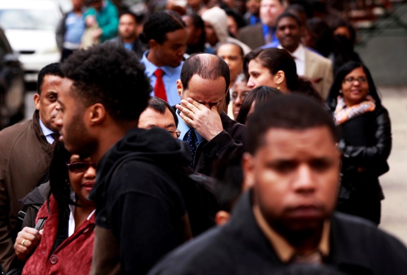 © Reuters. Man rubs his eyes as he waits in a line of jobseekers, to attend the Dr. Martin Luther King Jr. career fair held by the New York State department of Labor in New York
