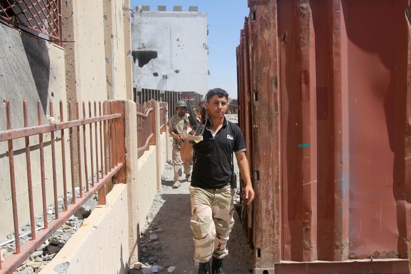 © Reuters. Members of Libyan forces allied with the U.N.-backed government patrol near government buildings that they captured following a battle with Islamic State militants in neighbourhood Number One in central Sirte