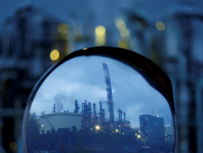 © Reuters. Chimneys of a factory are reflected in a traffic mirror at the Keihin industrial zone in Kawasaki, south of Tokyo, Japan