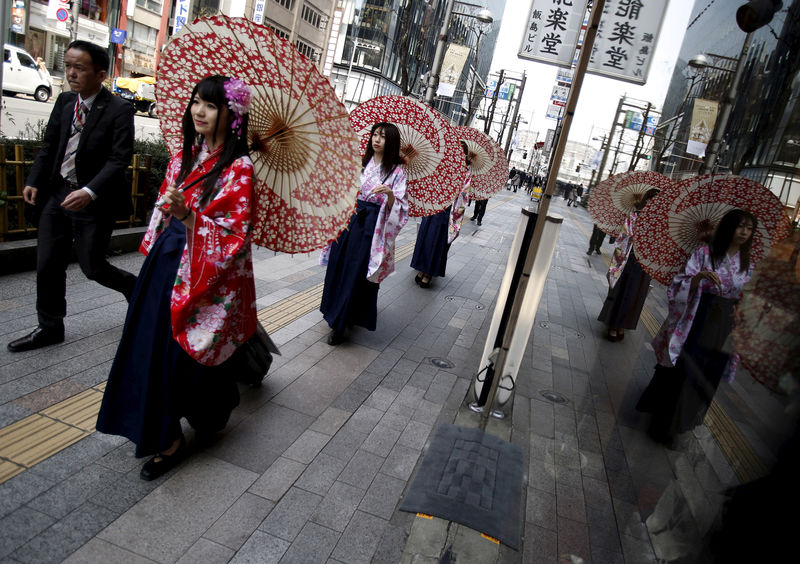 © Reuters. Women in Kimono holding an umbrella walk on a street at Ginza shopping district in Tokyo