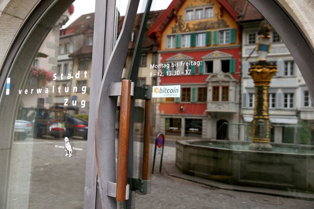 © Reuters. A sticker reading "Bitcoin accepted here" is displayed at the entrance of the Stadthaus town hall in Zug