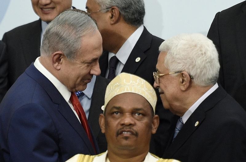 © Reuters. Israeli's Prime Minister Netanyahu talks with Palestine's President Abbas during a family photo for the opening day of the World Climate Change Conference 2015 (COP21) at Le Bourget