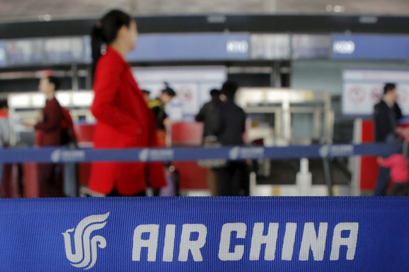 © Reuters. Passengers walk to ticket counters of Air China at a terminal of Beijing Capital International Airport in Beijing